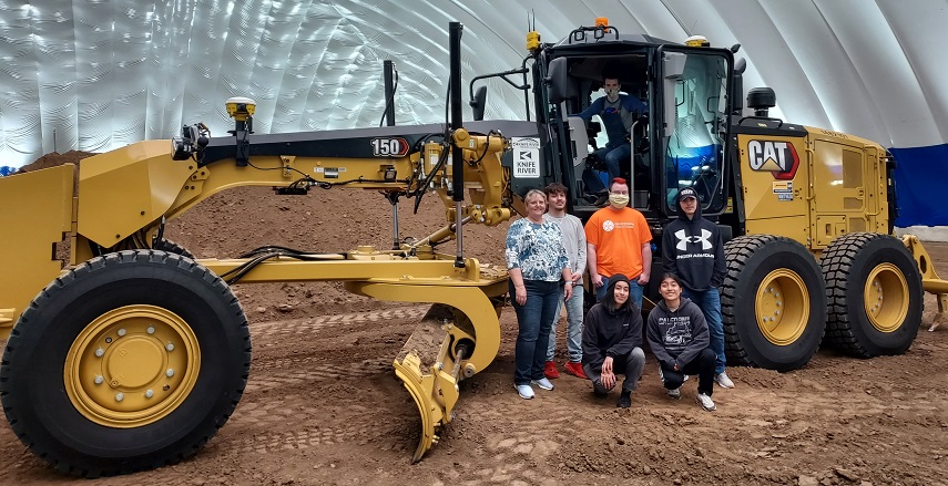 Pre-Apprenticeship students posing with a road grader